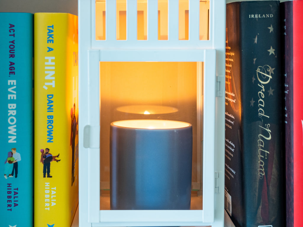 Candle in a lantern on a bookshelf